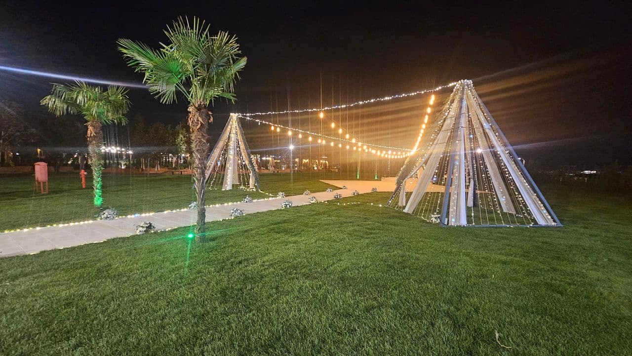 Nikah alanında ışıklı çadırlar ve yemyeşil çimler, gece
