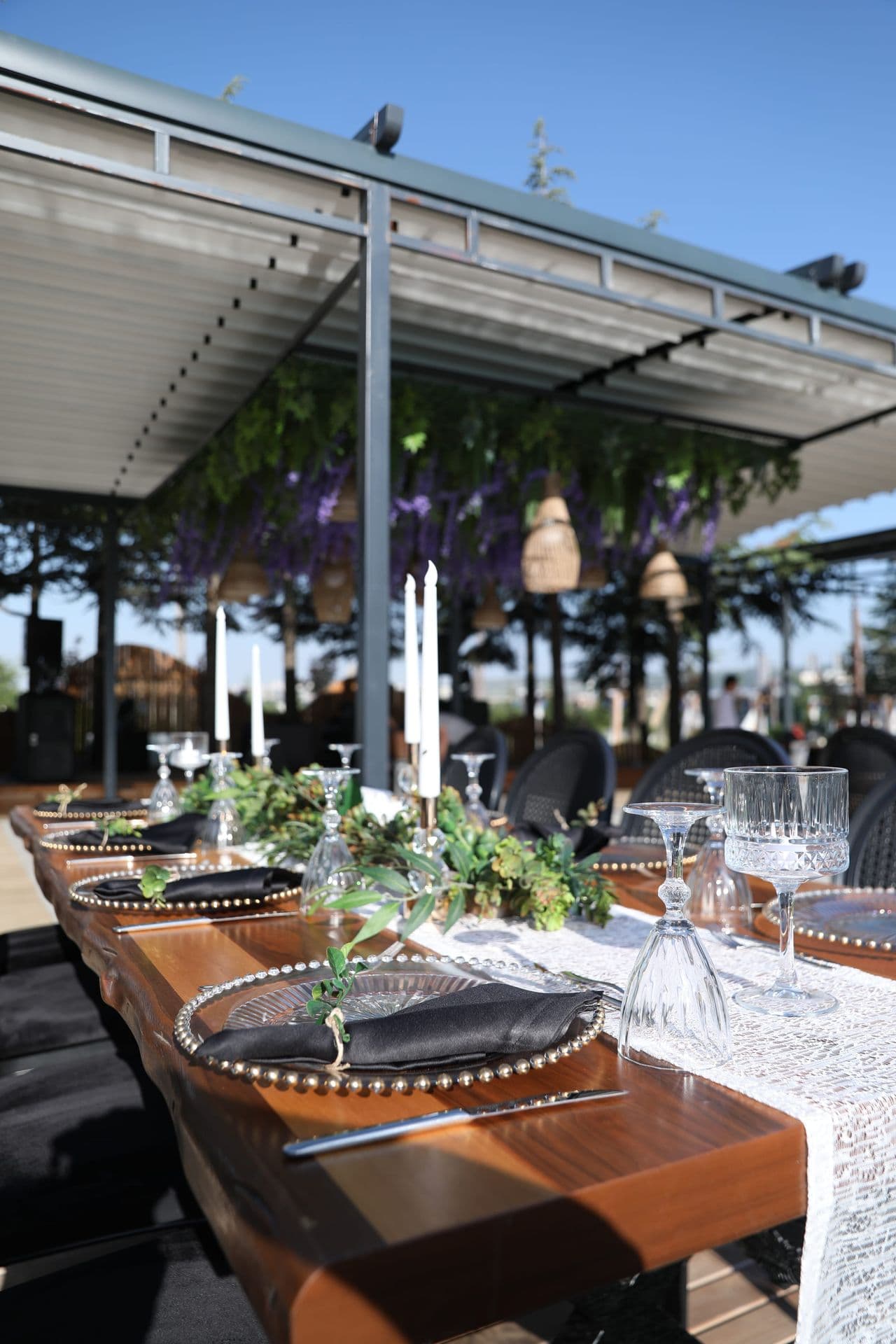 Mor salkımlı pergola altında şamdanlı masa